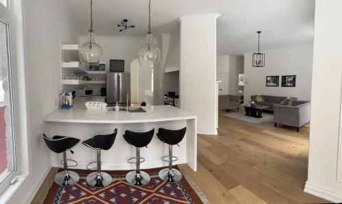une cuisine et un salon avec un comptoir et des chaises dans l'établissement Family friendly place with pool and jacuzzi, à Penetanguishene