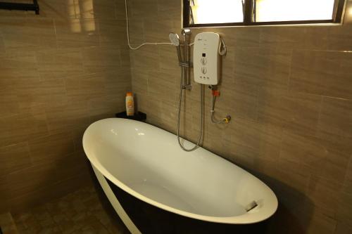 a bath tub in a bathroom with a window at Erliz villa in Kumasi