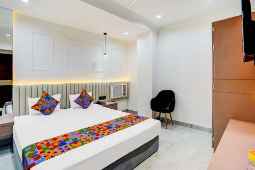 a bedroom with a bed with a colorful blanket on it at FabHotel Sanviraaj in Kānpur