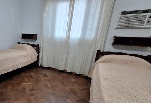a room with two beds and a window with curtains at Mejor zona de Paraná in Paraná