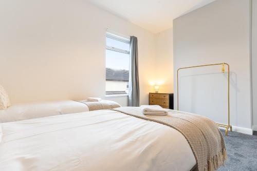a bedroom with two beds and a large window at Herschell House - Central Location - Free Parking, Fast Wifi, SmartTV with Netflix - Perfect for Contractors, Families and Groups by Yoko Property in Redcar