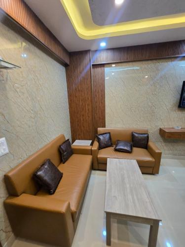 a waiting room with brown couches and a table at Cozy Studio in Ghaziabad