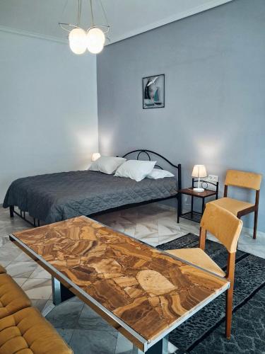 a bedroom with a bed with a wooden table and a tableablish at Villa Desire in Korinos