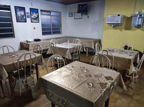 a dining room with tables and chairs with nets on them at Pousada Rezende in Caldas Novas