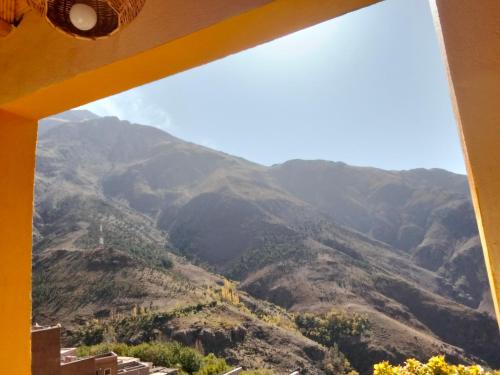 a view of the mountains through a window at riad atlas imnane in Imlil
