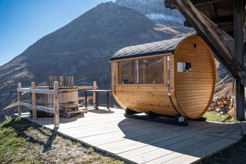 a round wooden cabin with a table and a mountain at Albergo Ristoro Sitten - 2300 mt in Gressoney-la-Trinité
