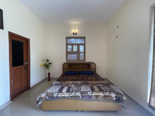 a bedroom with a large bed in a white room at Saanjh Farm in Gurgaon