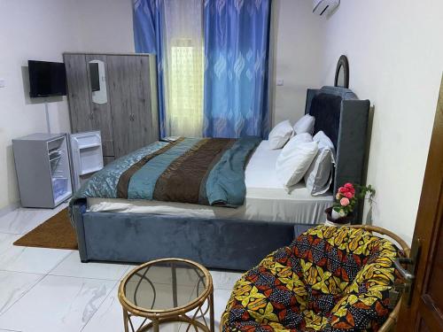 a bedroom with a large bed and two chairs at JD Hotel in Accra