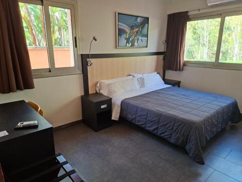 a hotel room with a bed and two windows at Hotel 170 in Castelldefels