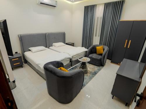 a hotel room with a bed and two chairs at قمة حياة للشقق المفروشة in Hafr Al Baten