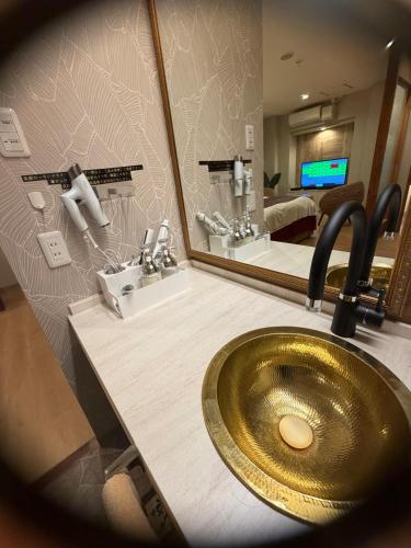 a bathroom with a gold sink and a mirror at リンドス in Okayama