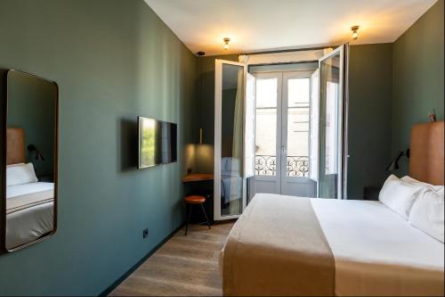 a hotel room with a bed and a mirror at Colectia Stays Atocha in Madrid