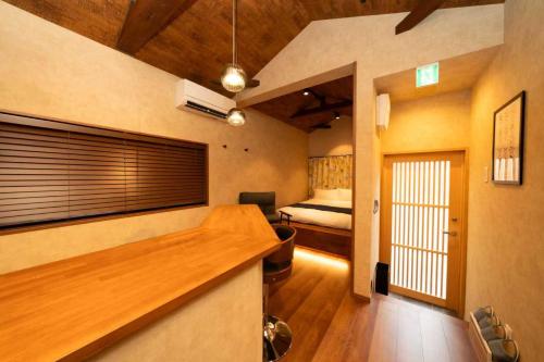 Zimmer mit einem Schlafzimmer mit einem Bett und einem Schreibtisch in der Unterkunft 三十三Daichi in Wada