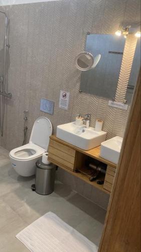 a bathroom with a toilet and a sink and a mirror at Villa Sénégal Elise in Ngaring