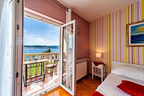 a bedroom with a bed and a balcony with a view at Bed & Breakfast Villa Vrgorac in Orebić