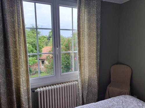 ein Schlafzimmer mit einem Bett und einem Fenster mit einem Heizkörper in der Unterkunft Clos St Vaast près plage et port in Saint-Vaast-la-Hougue