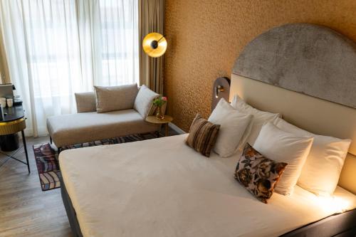 a hotel room with a bed and a chair at Boutique Hotel Albus Amsterdam Centre in Amsterdam