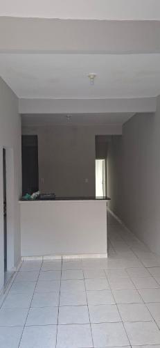 an empty room with a white wall and a white tile floor at Apartamento in Belém