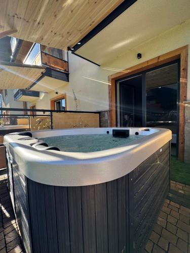 een hot tub in het midden van een huis bij Kominkowy Chill - prywatne zewnętrzne jacuzzi w wybranych apartamentach in Biały Dunajec