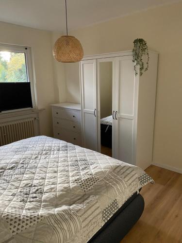 ein Schlafzimmer mit einem Bett, einer Kommode und einem Fenster in der Unterkunft Frieslandliebe in Schortens