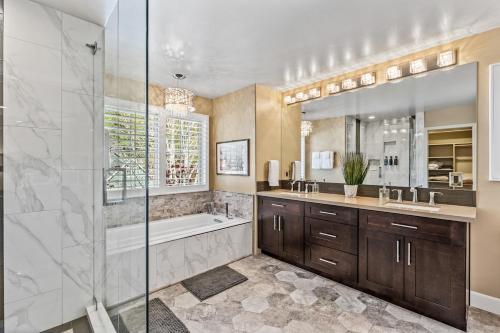 a bathroom with a shower and a tub and a sink at Minutes 2 NAU & downtown & Snowbowl! in Flagstaff