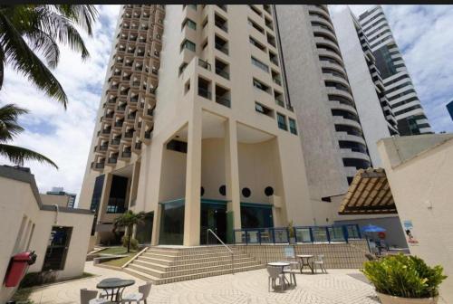 un edificio con escaleras y mesas delante en Recife Mar Flat, en Recife