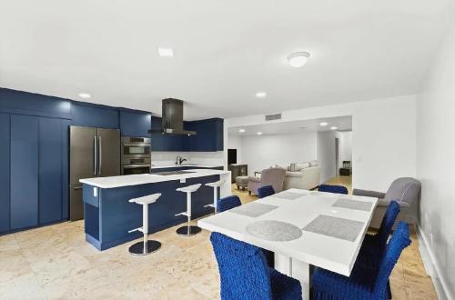 a kitchen with a white table and blue cabinets at Bright Three-Bedroom Modern Apartment with Private Balcony in Hollywood Beach