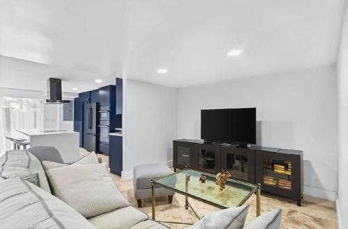 a living room with couches and a tv and a fireplace at Bright Three-Bedroom Modern Apartment with Private Balcony in Hollywood Beach