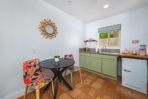a kitchen with a table and chairs and a sink at Fleur Noire Hotel - 21 and Over in Palm Springs