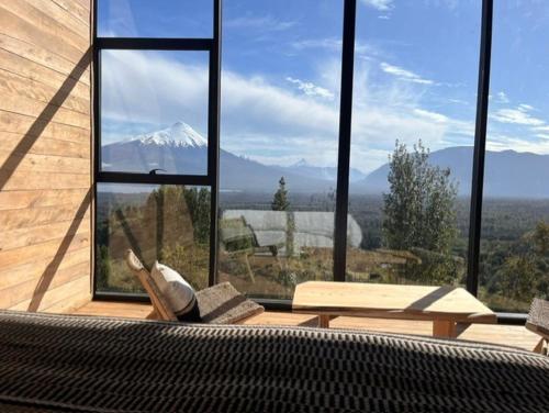 una persona tumbada en un sofá frente a una ventana en Ampe Lodge, en Puerto Varas