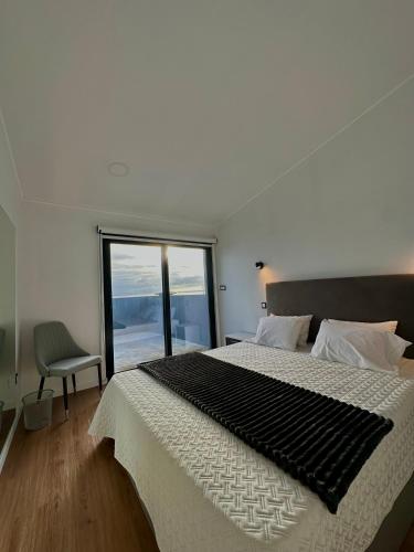 a bedroom with a large bed with a large window at The Mill House in Lagoa
