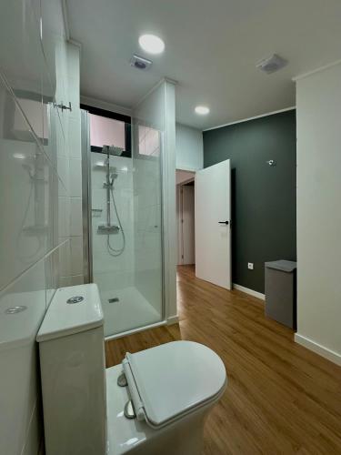 a bathroom with a toilet and a glass shower at The Mill House in Lagoa