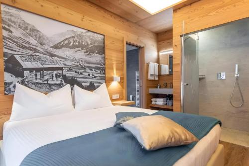 a bedroom with a king sized bed with a painting on the wall at Chalet Imbosc'chè 5 rooms Bnb in Livigno