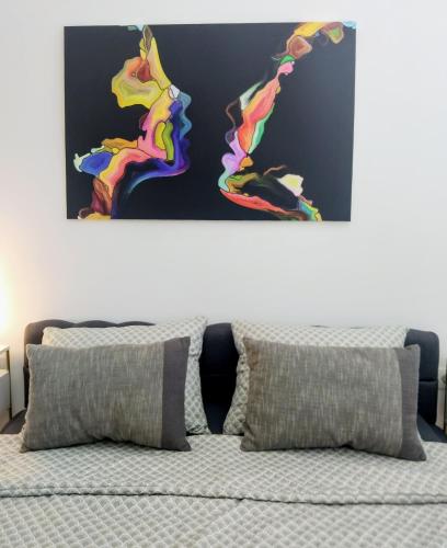 a bedroom with a bed with two paintings on the wall at Apartments Ana in Maribor
