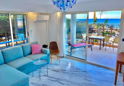 een woonkamer met een blauwe bank en uitzicht op de oceaan bij Beach and Sea View in Roquebrune-Cap-Martin