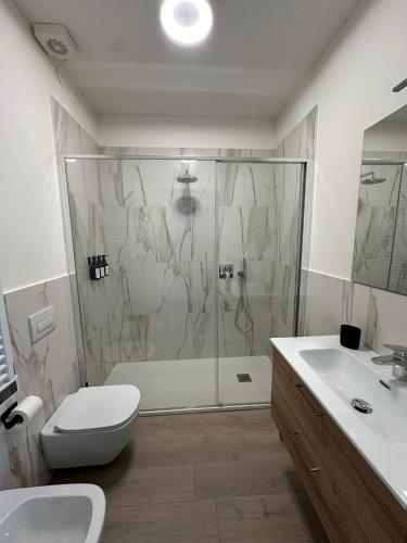 a bathroom with a shower and a toilet and a sink at OFF 32 Suites in Melzo