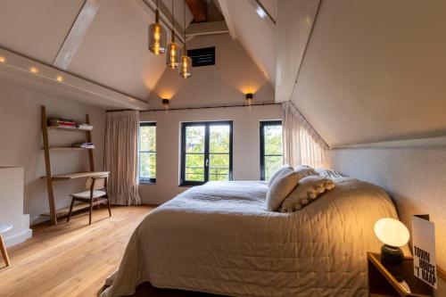 a bedroom with a large bed and two windows at Townhouse 't Raap in Amsterdam