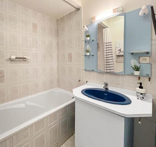 ein Badezimmer mit Waschbecken, Badewanne und Spiegel in der Unterkunft Vue mer panoramique, Loggia Salon, Parking Privé in Saint-Hilaire-de-Riez