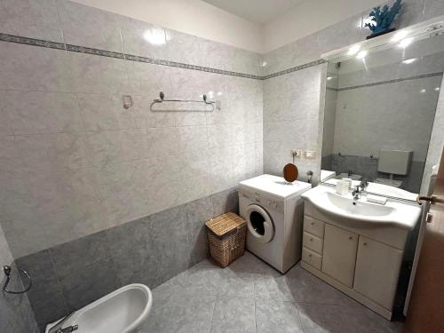 グラードにあるPosta Vecchiaの洗濯機と洗面台を備えたバスルーム