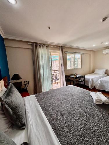 a large bedroom with two beds and a window at Flat Barra Residence-4 pessoas-Fa1204-3 in Rio de Janeiro