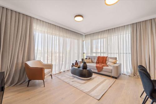 una sala de estar con un sofá y una mesa en Savyon View 2 Bdr By Isrentals, en El Muṣrāra