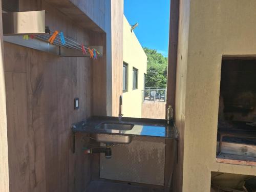 a bathroom with a sink next to a door at Hermosa casa de playa in Mar de las Pampas