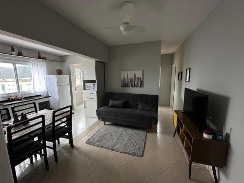 una sala de estar con un sofá y una mesa en Frente ao Mar - Acorde Com o Barulho das Ondas apto 10, en Praia Grande