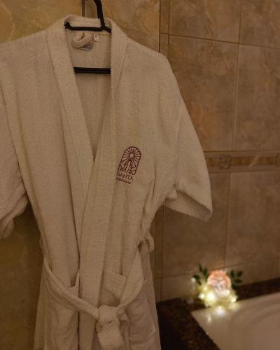 Una bata blanca en un perchero en un baño. en Loft p/ casal hidro, café, a/c e vista, en Santo Amaro da Imperatriz