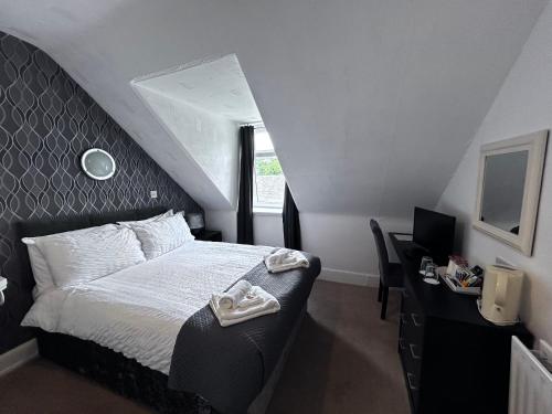a bedroom with a bed and a desk with a computer at Glendale Guesthouse in Oban