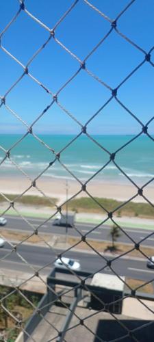 a chain link fence with a view of the beach at Maison Chateaubriand Residence in Maceió