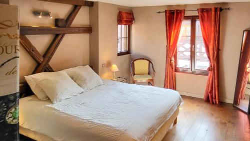 een slaapkamer met een wit bed en 2 ramen bij La Tour de la Chapelle - Parking privé in Obernai
