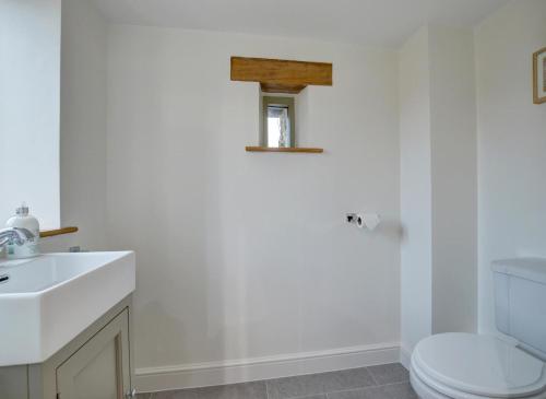 a bathroom with a white toilet and a sink at Barton Barn in Bishops Nympton