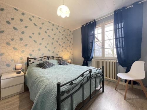 a bedroom with a bed and a chair in it at Jardin fleuri in Sus