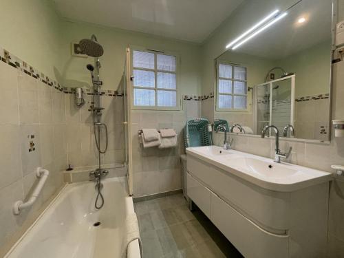 a bathroom with a tub and a sink at Jardin fleuri in Sus